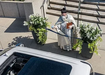 Вижте свещеника, който гони вируса с воден пистолет