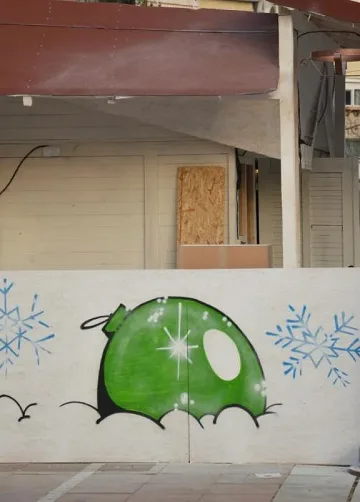 Художник рисува върху коледни къщички