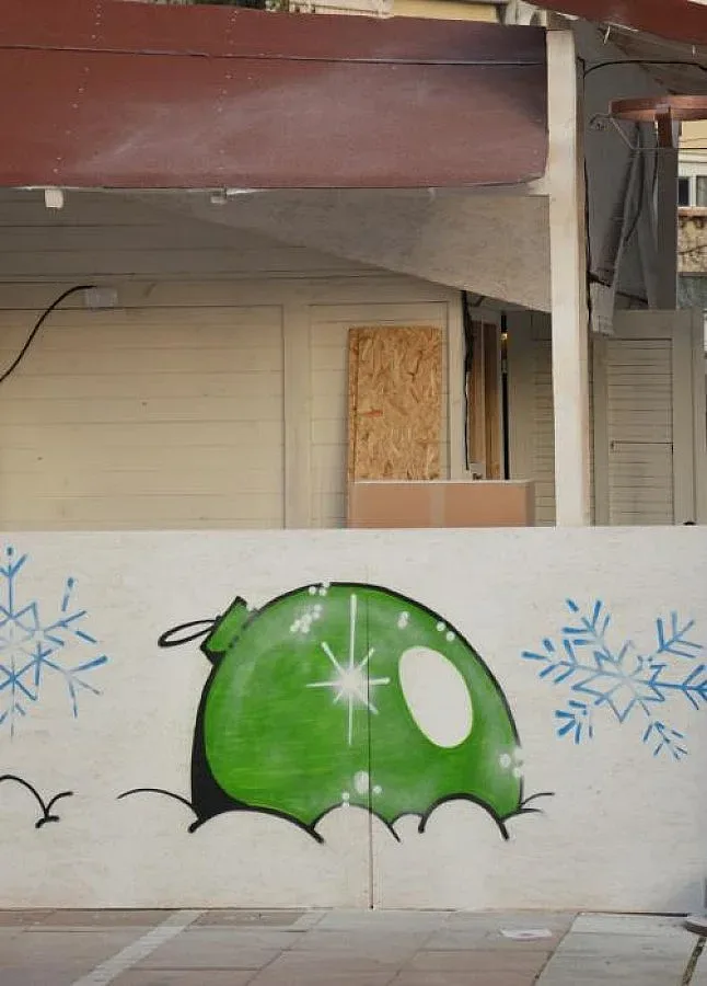 Художник рисува върху коледни къщички