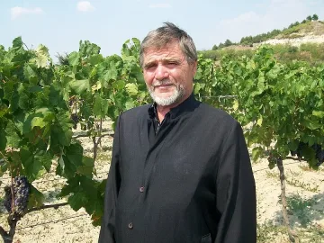 Свещеник копае лозе, за да върже двата края