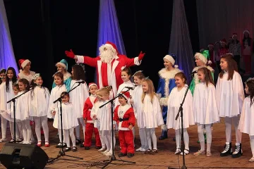 Деца с коледен подарък за родители и гости