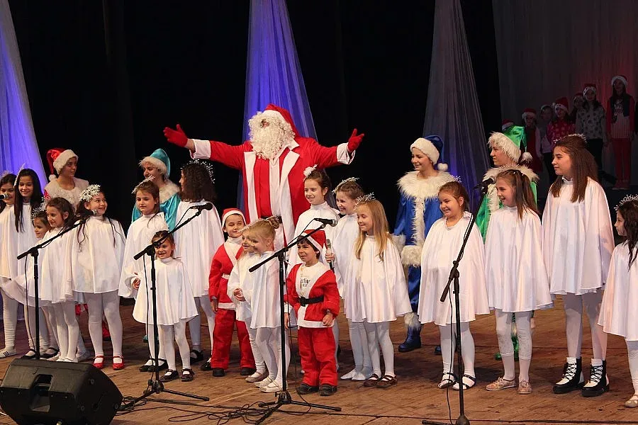 Деца с коледен подарък за родители и гости