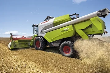 Мъж сряза гуми на комбайн