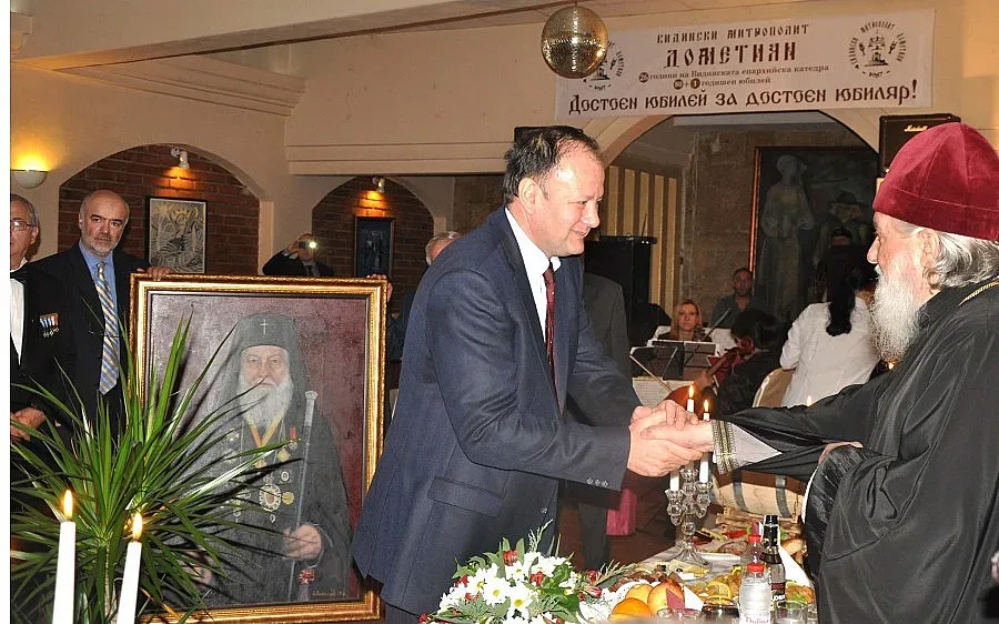 Дариха Дометиан с църковни одежди, автомобил и портрет