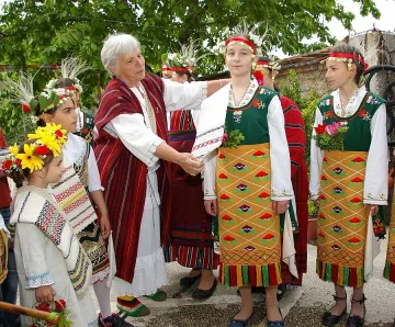  Русо момиче носи куклата Лазар