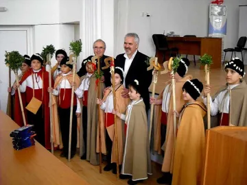 Кмет дари коледари с библии