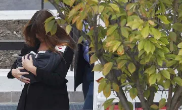 Камерън завива бебето на Саркози