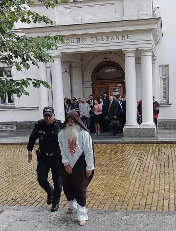 Снимката обиколила мрежата. Кой е човекът под дъжда пред парламента